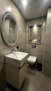 a bathroom with a sink and a mirror and a toilet at Supernova suite in New Delhi
