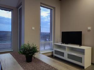 a living room with a flat screen tv on a dresser at Complex Karia I in Kavarna