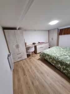 a bedroom with a bed and a desk with a chair at Granville, sous-sol aménagé en bel appartement in Granville