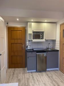 a kitchen with white cabinets and a stove top oven at pokoje gościnne u znajomej in Darłowo