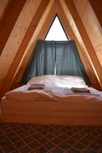 a bed in a pitched room with a window at Kirari Mount Camp in Zemo-Margi