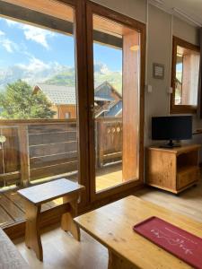 a living room with a table and a large window at Les Chalets De Superd Ancolie - APPARTEMENT DANS CHALET DE 30 LOGEMENTS EXPO SUD MAE-8854 in Le Dévoluy