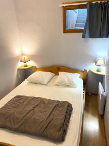 a bedroom with a bed with two lamps on both sides at Les Chalets De Superd Ancolie - APPARTEMENT DANS CHALET DE 30 LOGEMENTS EXPO SUD MAE-8854 in Le Dévoluy