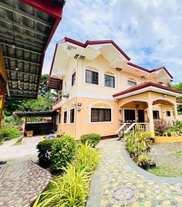 a house with a courtyard in front of it at Chateau La Princesa rooms with garden, Bar & billiard in Puerto Princesa City