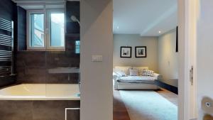 a bathroom with a tub and a couch in a room at Villa Sablon in Brussels