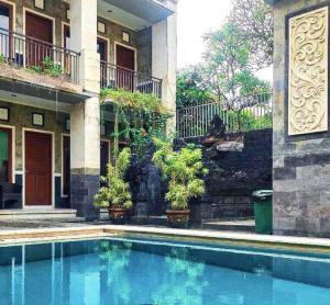 a swimming pool in front of a building at SG Hotel - 2 Minutes to the Beach By Micky Studio 2 in Legian