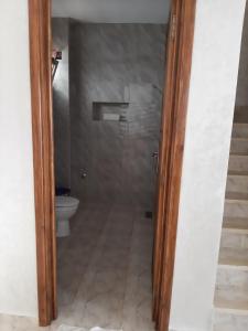 a bathroom with a toilet and a glass door at Beach Front Villa in Souira Guedima