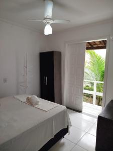 a bedroom with a bed with a ceiling fan at JL Temporadas - Apto Village Taperapuan in Porto Seguro
