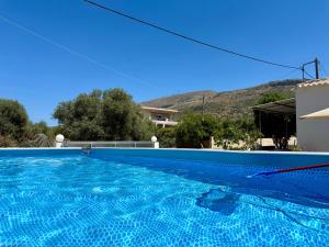 a blue swimming pool in front of a house at Cretan Blue Bungalow Chania in Chania