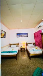 a room with two beds in a room at Chateau La Princesa rooms with garden, Bar & billiard in Puerto Princesa City