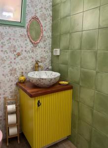 a bathroom with a sink on a yellow cabinet at Matilda's house in Majdal Shams
