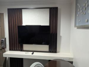 a flat screen tv sitting on a wall at Airport Motel - Inglewood in Inglewood
