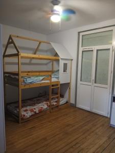 a bunk bed in a room with a door at Grande maison de bourg in Montpon-Ménestérol