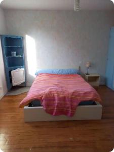 a bedroom with a bed with a pink blanket on it at Grande maison de bourg in Montpon-Ménestérol