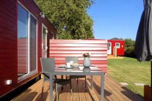 a patio with a table and chairs on a deck at Ostsee Tiny Haus Spatz in Barth