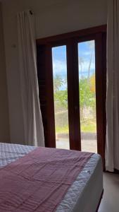 a bedroom with a bed and a sliding glass door at Chalés Dunas - Icaraí de Amontada in Amontada