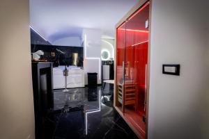 Un baño con suelo de baldosas negras y una puerta roja. en Palermo Luxury Rooms Black, en Palermo