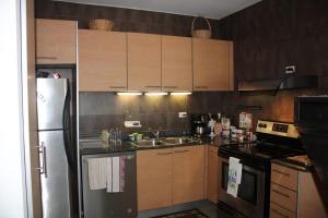 a kitchen with wooden cabinets and a stainless steel refrigerator at Apartmento en Playa Blanca Rio Hato in Río Hato