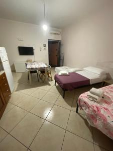 una camera con due letti e un tavolo di House Vacations Center a Castellammare di Stabia