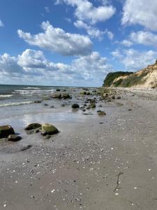 a beach with rocks and the ocean on a cloudy day at Ostseeliebe in Grömitz +18 photos