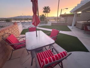 uma mesa e cadeiras com um guarda-sol em um pátio em RIVERFRONT RUBY RED HOME WITH PRIVATE DOCK em Bullhead City