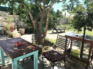 a picnic table and chairs in a yard with a tree at Zorin House Rooms in Jezera