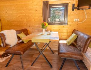 a dining room with a table and two chairs at Peryton Houses -Chalets zum Wohlfühlen in Sinsheim