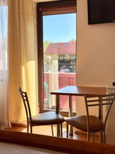 a table and chairs in a room with a window at Akmuo Ant Akmens in Šventoji