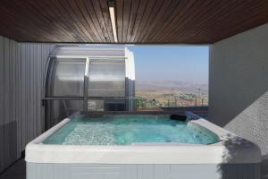 a hot tub in a room with a large window at Villa Aqua Boutique in Safed