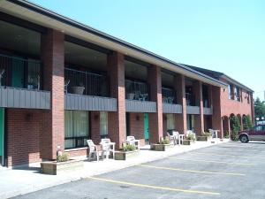 un edificio con muchas sillas en un estacionamiento en Motel Du Chevalier, en Gatineau