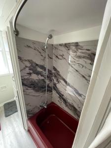 a shower with a red tub in a room at Cabernet Sauvignon Escape in Calgary +17 photos