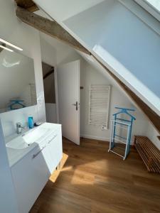 a white bathroom with a sink and a mirror at Charmant corps de ferme réhabilité en Mayenne in Daon