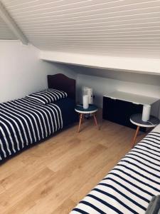 a room with two beds and two tables in it at Duplex 90 m2, Le Touquet, quartier Westminster 3 chambres, 6 couchages, 1 parking, Location à la semaine en juillet, août et pendant les semaines de vacances scolaires de fin d'année, sinon 2 nuits minimum in Le Touquet-Paris-Plage