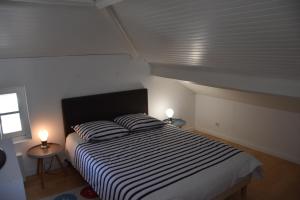 a bedroom with a bed with two pillows on it at Duplex 90 m2, Le Touquet, quartier Westminster 3 chambres, 6 couchages, 1 parking, Location à la semaine en juillet, août et pendant les semaines de vacances scolaires de fin d'année, sinon 2 nuits minimum in Le Touquet-Paris-Plage
