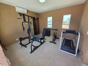 a gym with treadmills and cardio equipment in a room at Flat Flecheiras in Trairi
