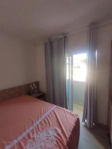 a bedroom with a bed and a sliding glass door at Flat Flecheiras in Trairi +8 photos
