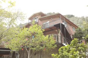 ein großes Holzhaus mit Balkon und Bäumen in der Unterkunft Ahsen pansiyon in Selçuk