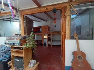 a room with a guitar and a room with a bed at Antiques Homestay in Pisac