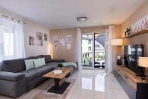 a living room with a couch and a tv at Blue Sky Flat, Apartment, 73qm, 4-6 Personen, Neubau Süd-Balkon mit Lounge-Möbeln, Schwarzwald-PLUS inkl 80 Gratis-Attraktionen täglich in Baiersbronn