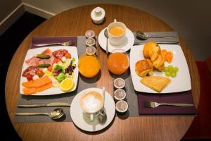 a table with two plates of breakfast foods and drinks at Hotel EDEN CLIFF Near DELHI AIRPORT in New Delhi