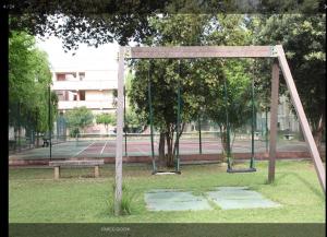 La Perla di Alghero في ألغيرو: أرجوحة في حديقة مع مقعد +27 صورة