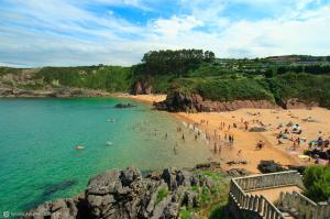 a group of people on a beach in the water at Alvares de Corvera in El Pontón