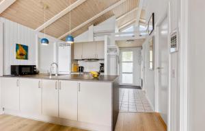 a kitchen with white cabinets and a wooden ceiling at Holiday Home Rævebæk Sydals Denm in Skovby