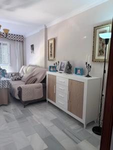 ein Wohnzimmer mit Sofa und Tisch in der Unterkunft Casa Coplas muy cerca de la playa in Sanlúcar de Barrameda