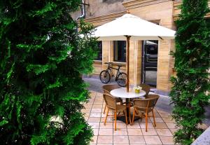 a table and chairs under an umbrella on a patio at MGA Hostel & Tours in Yerevan