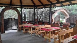 a restaurant with tables and chairs in a pavilion at Mića Alas vikendica in Orljane