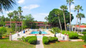 ein Resort mit einem Pool und Palmen in der Unterkunft Motel 6-Spring Hill, FL - Weeki Wachee in Weeki Wachee