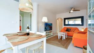 a living room with an orange couch and a table at Apartamento Punta Glea in Orihuela Costa