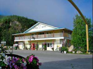 a large building with a large parking lot with flowers at Bonanza Gold Motel in Dawson City