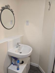 a white bathroom with a sink and a mirror at Cozy room in Wolverhampton city centre in Wolverhampton